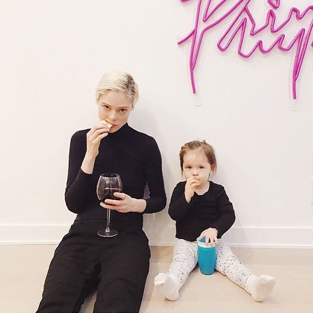 Adult and toddler sitting together, both eating snacks, with toddler holding a blue cup