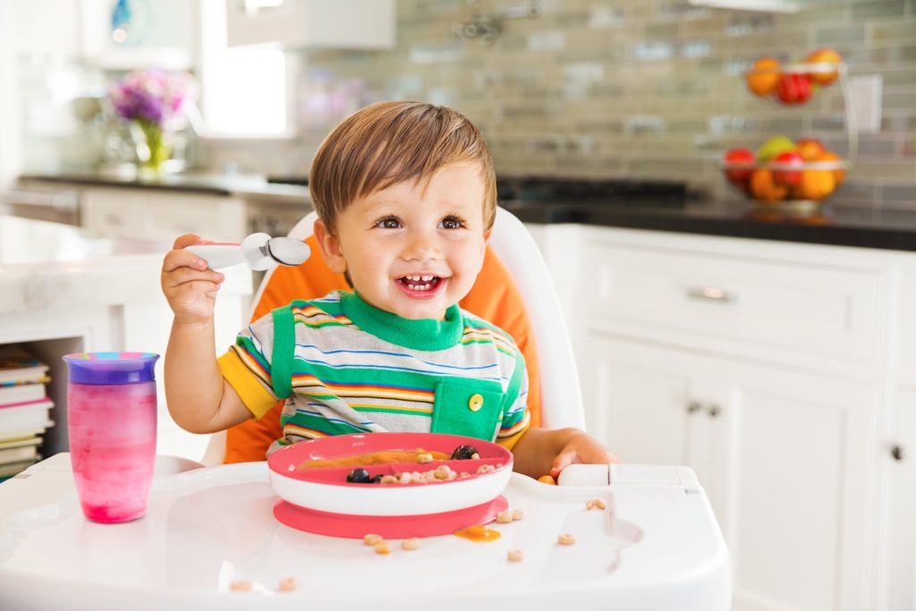 child with sippy cup and plate