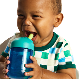 Toddler drinking from a Munchkin sippy cup with teal and blue design