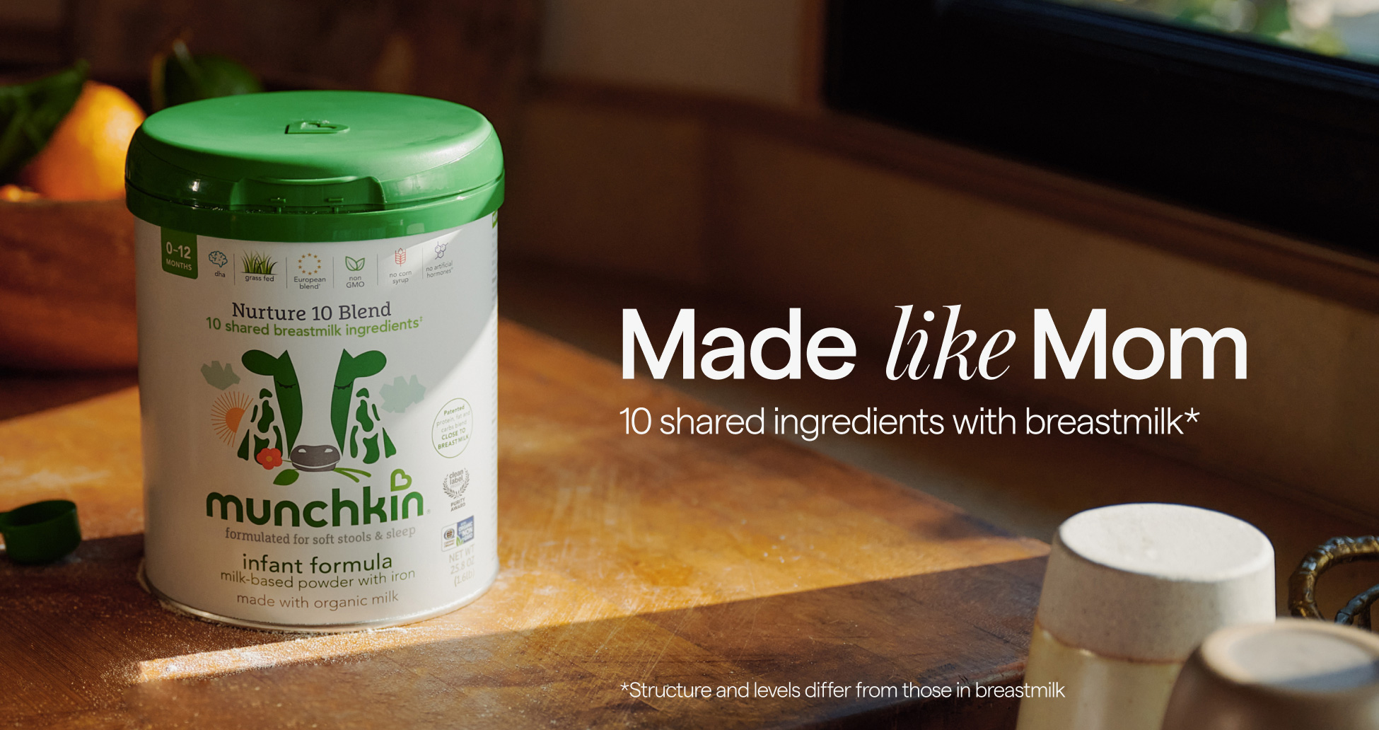 Munchkin Infant Formula can on wooden surface, with text "Made like Mom, 10 shared ingredients with breastmilk* Also available at your local Target store. *Includes patented protein, fat and carbs blend; 10 shared breastmilk ingredients, structure and level differ."